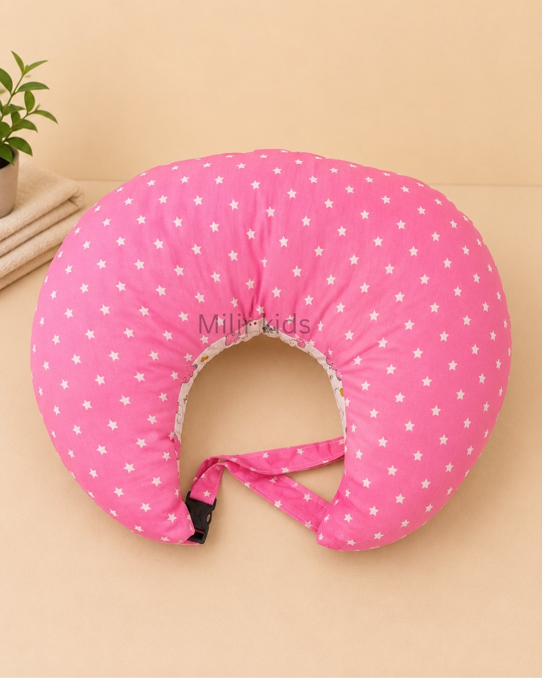 Pink baby feeding pillow with safety strap for breastfeeding and bottle feeding by Milir Kids