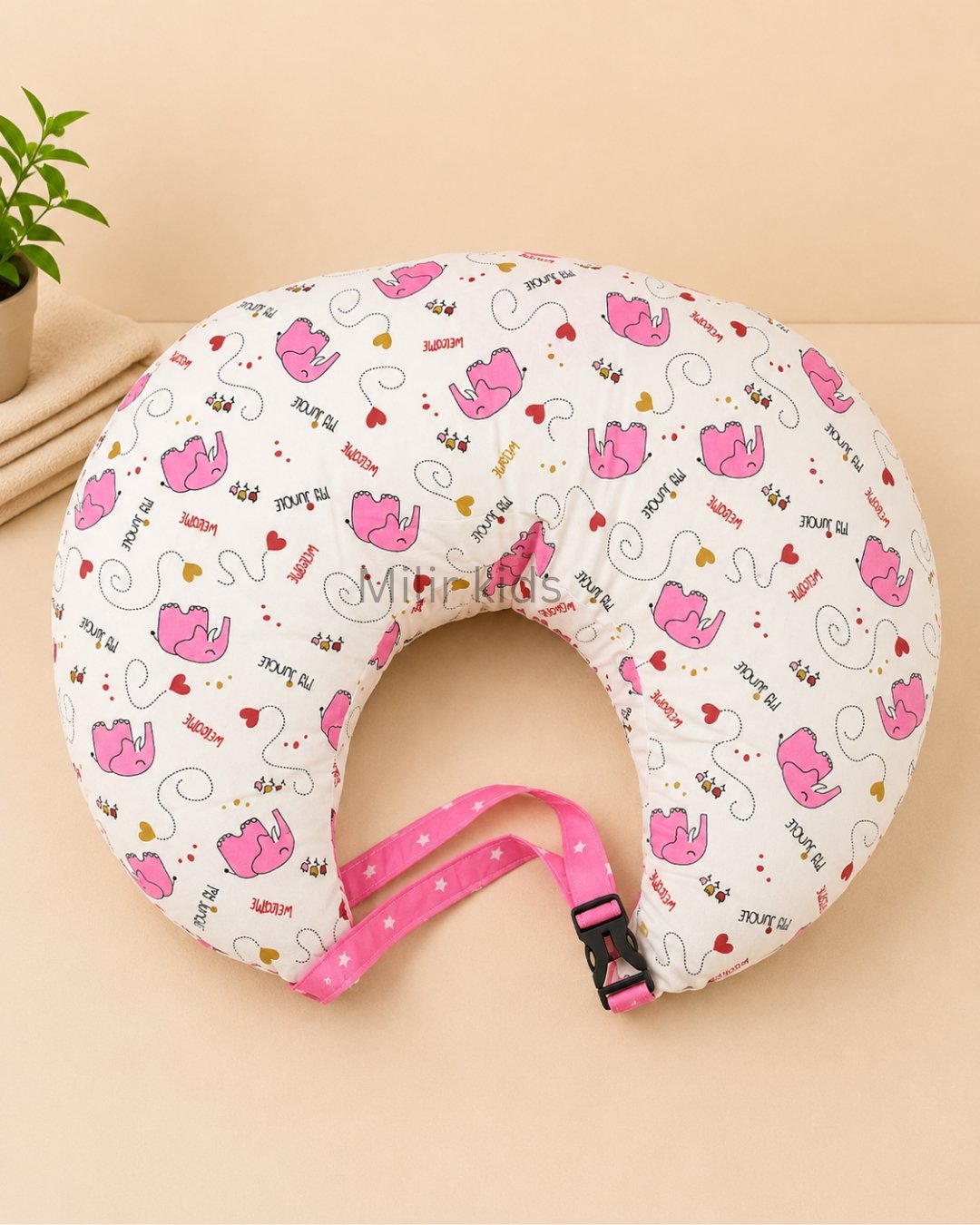 Pink baby feeding pillow with safety strap for breastfeeding and bottle feeding by Milir Kids